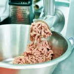 Electric meat grinder spins minced meat
